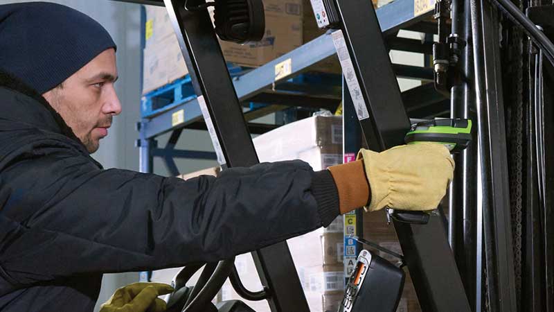 Worker using an ultra-rugged scanner on a forklift in a warehouse