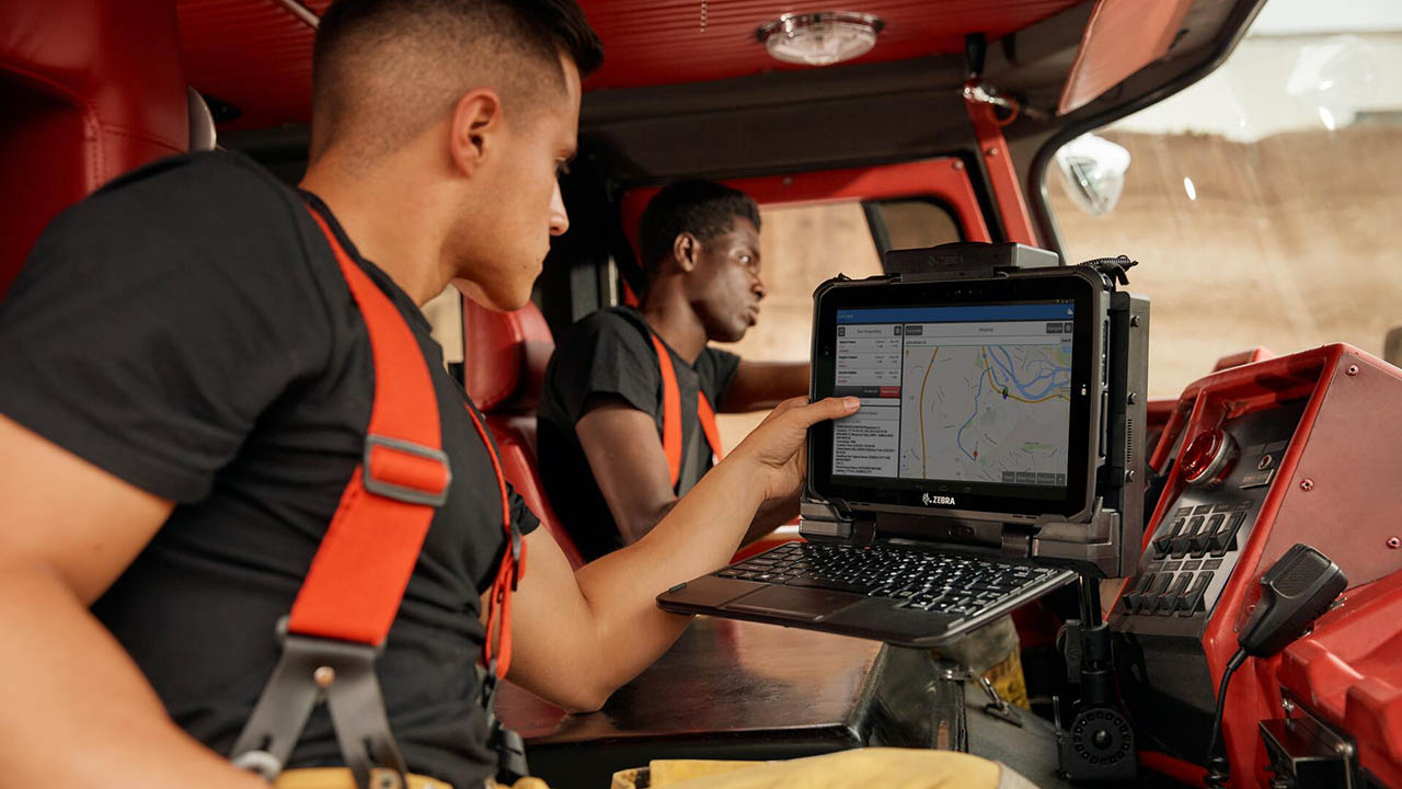 Firefighters look at the screen of a Zebra ET8x rugged tablet in their engine