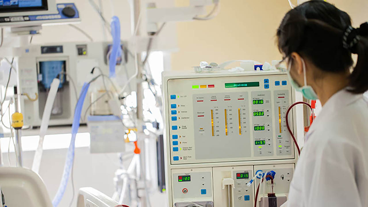 A nurse uses a dialysis machine