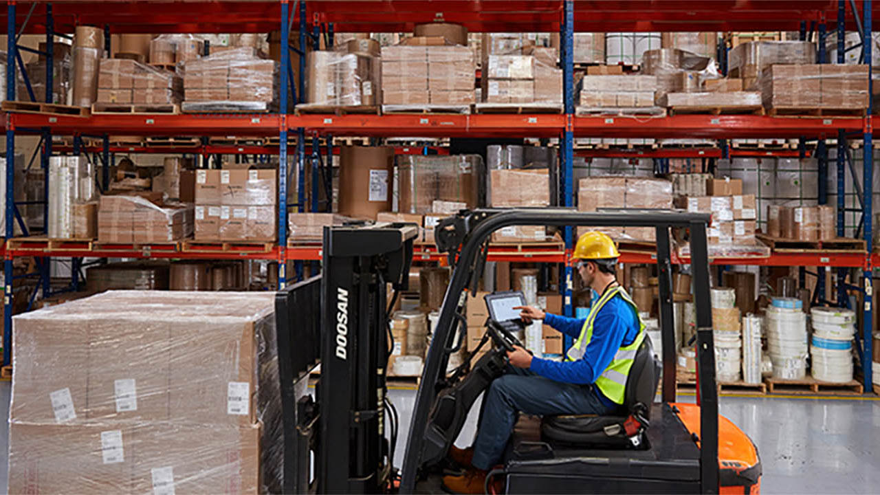 A forklift operator moves boxes in a RevLogical distribution center