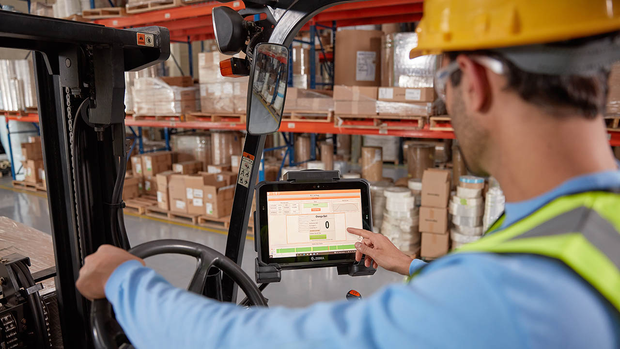 A forklift operator touches the screen on his vehicle-mounted Zebra ET8x 5G rugged tablet