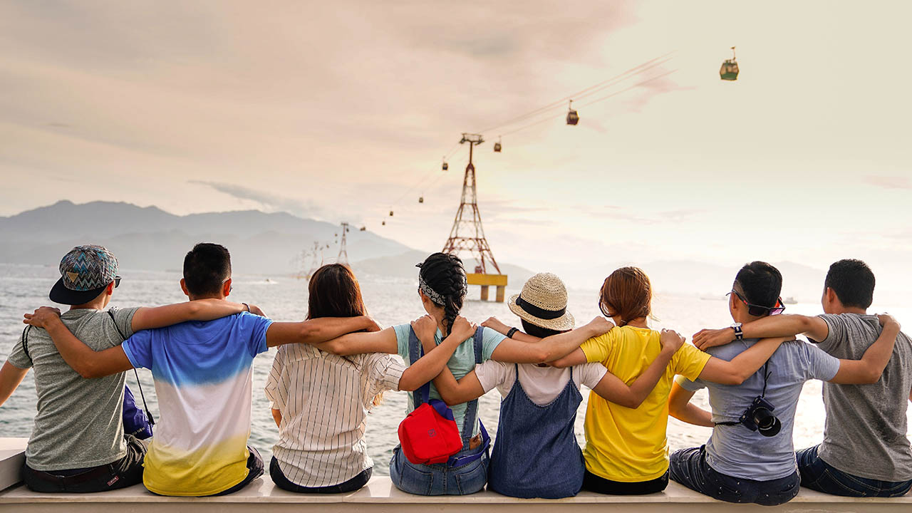 A group of friends sit together overlooking the bay