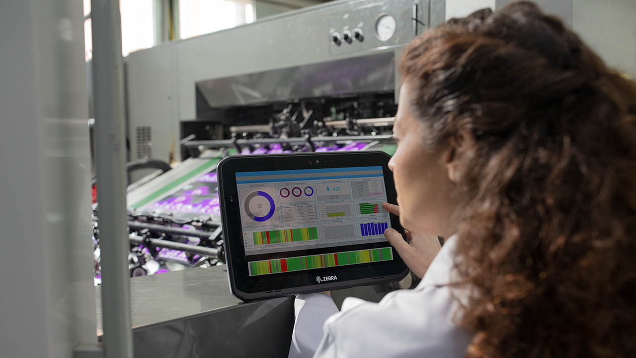 A manufacturing line inspector reviews quality data presented on her Zebra rugged tablet