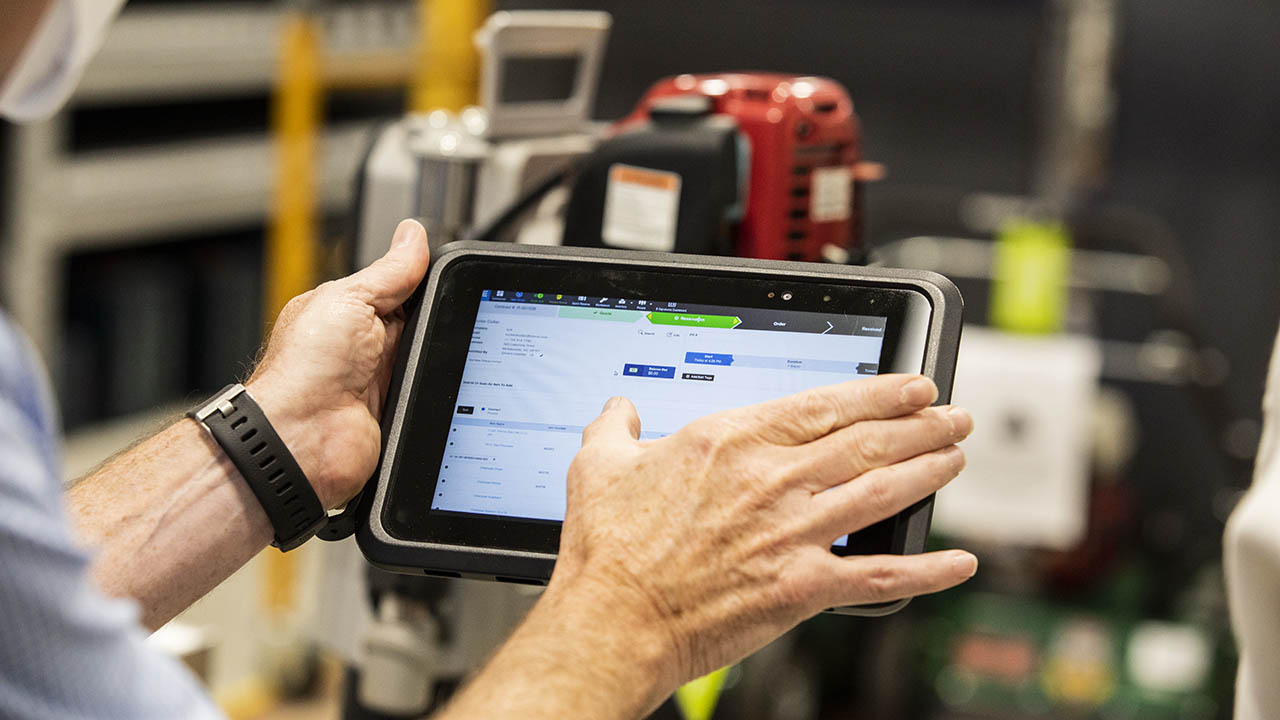 A Lowe's associate refers to a Zebra workforce management app on a Zebra tablet