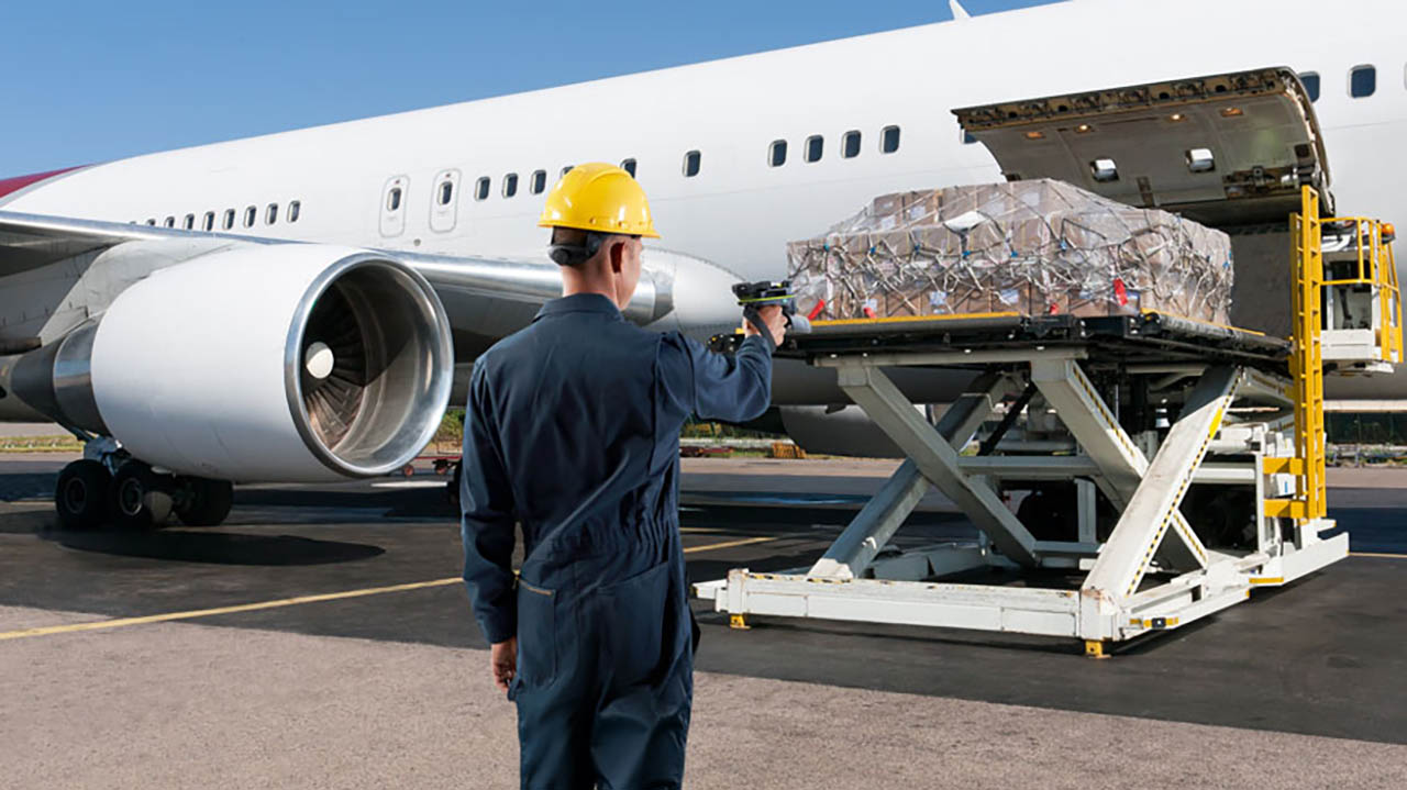 An airline worker uses a Zebra RFD90 ultra-rugged sled to read RFID tags on cargo being unloaded from an airplane