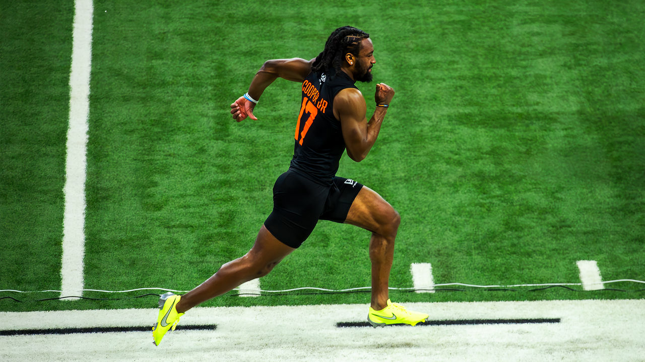 Athlete sprints in profile on a turf football field